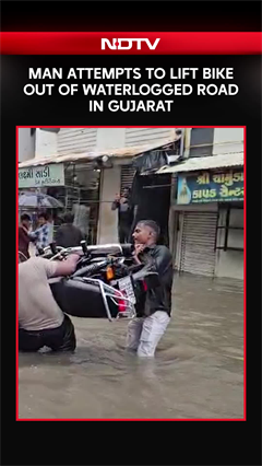 Gujarat Rains | Man Attempts to Lift Bike Out of Waterlogged Road in Gujarat