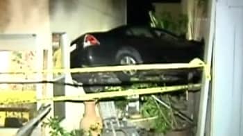 Driver crashes into two homes, leaving car suspended in air