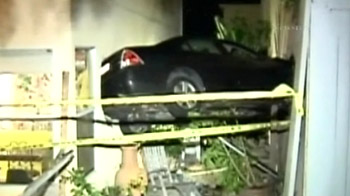 Driver crashes into two homes, leaving car suspended in air
