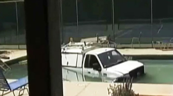 Truck plunges into community swimming pool